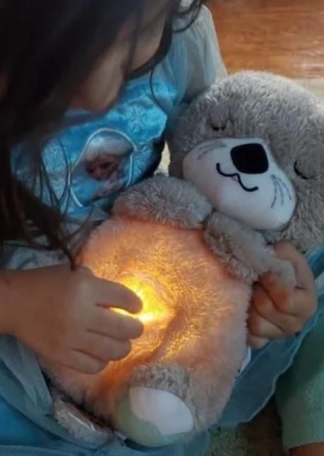 Child holding a glowing teddy bear with a warm light